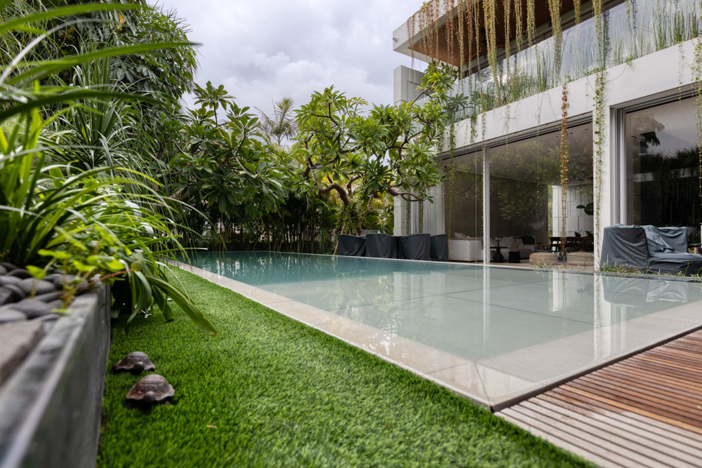 Specials for residential pools 3 | zwembadtechniek A beautiful green residential outdoor living space with a swimming pool, movable floor and acrylic underwater windows.